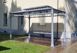 Pérgola con columnas de fundición y adornos de forja