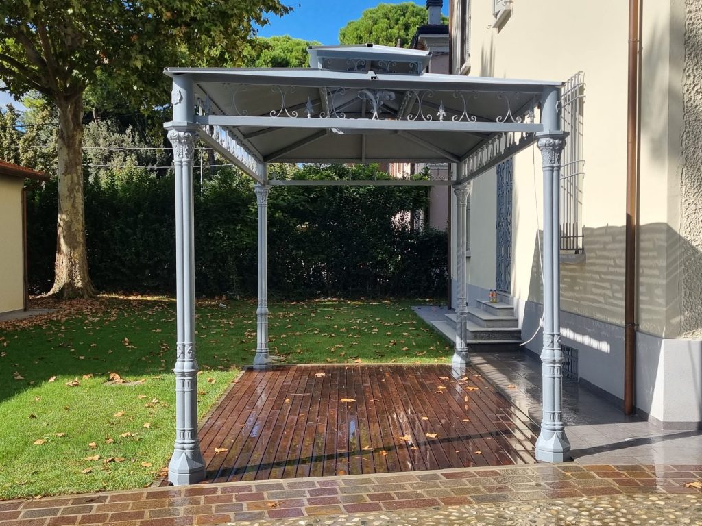 Pérgola con columnas de fundición y adornos de forja